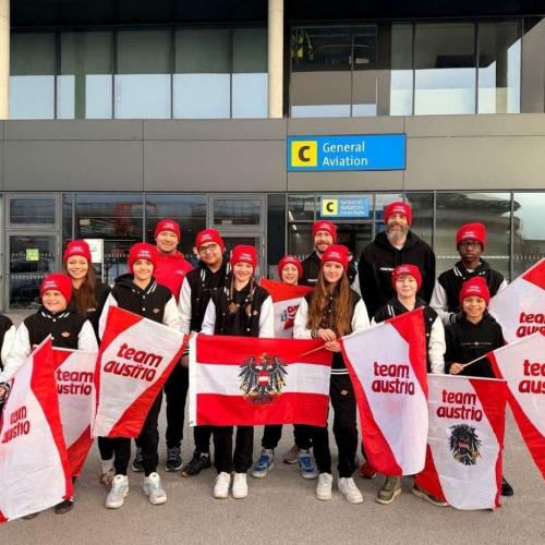 Bild zeigt das Team mit Österreichfahnen am Innsbrucker Flughafen