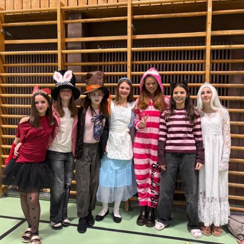Schülerinnen und eine Lehrerin mit Kostümen aus Alice im Wunderland
