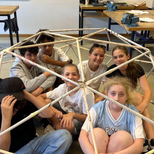 Das Foto zeigt Schüler*innen unter dem Bauwerk