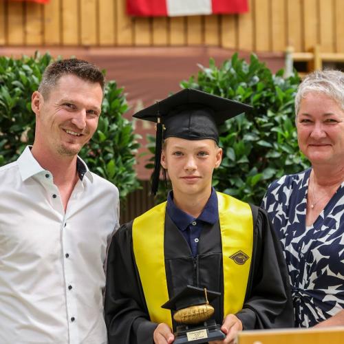 Das Foto zeigt den besten Footballspieler des Jahrgangs mit Direktorin und Klassenvorstand/Trainer