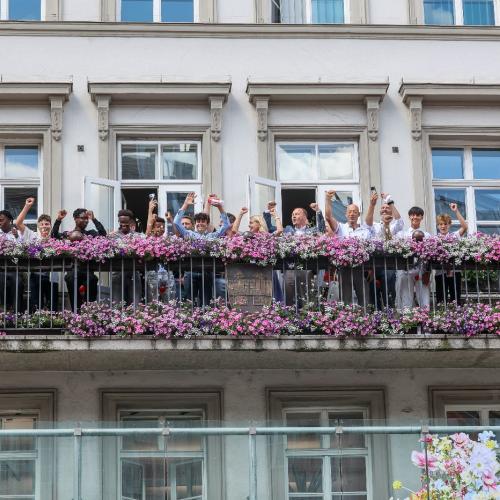 Das Bild zeigt die Spieler auf dem Balkon des Rathauses