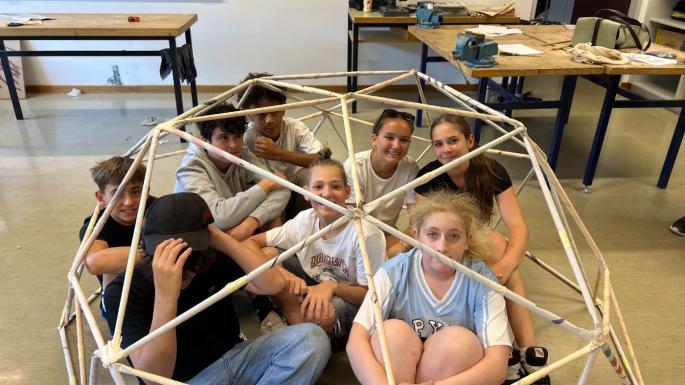 Das Foto zeigt Schüler*innen unter dem Bauwerk