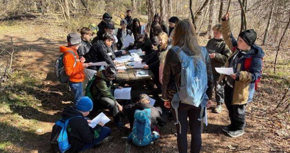 Das Bild zeigt Schüler an einem Tisch sitzend
